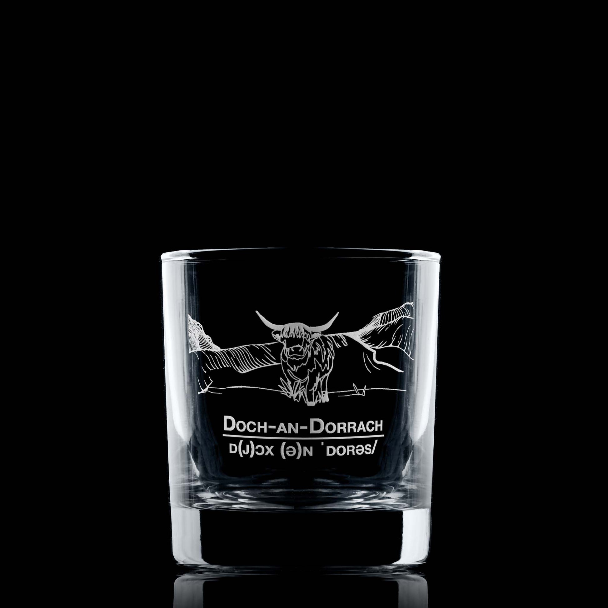 Engraved whisky glass featuring a Highland Cow, framed by mountains and anchored with the toast “Deoch an Dorrach”.