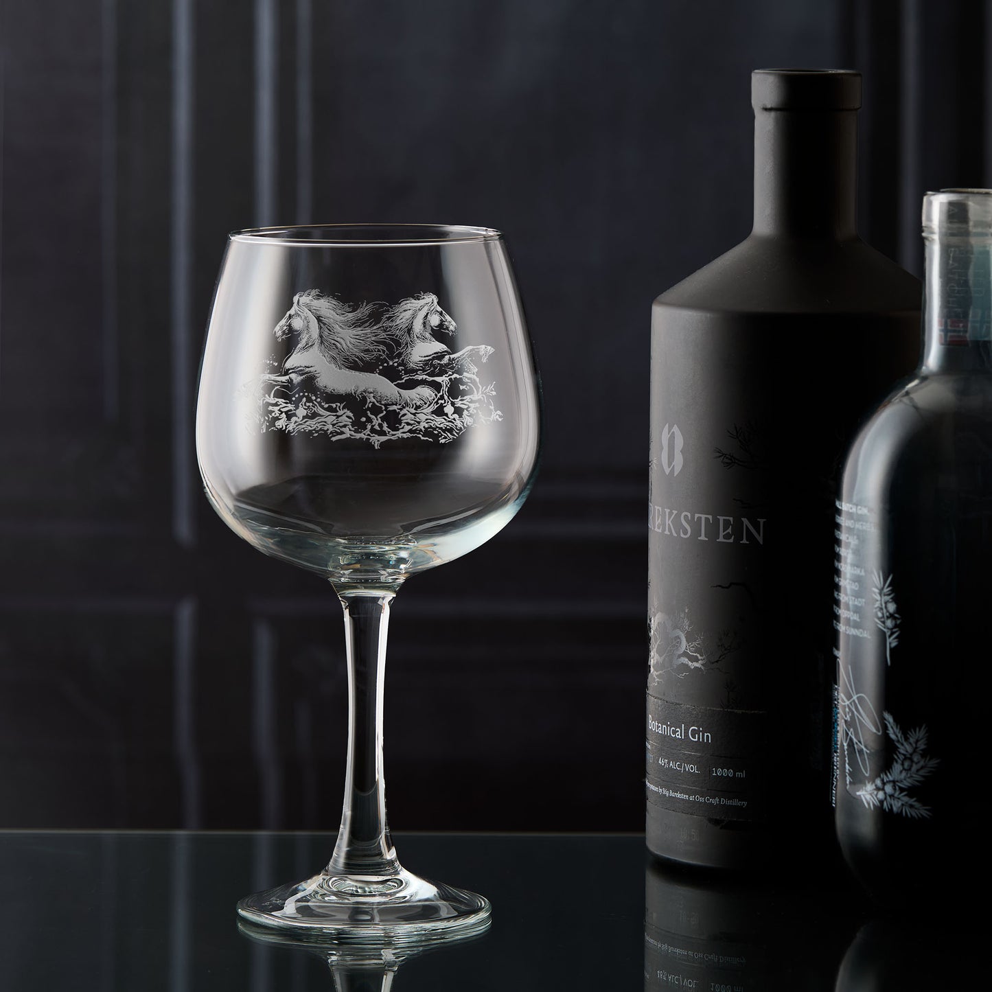 Gin glass engraved with two horses galloping through the water