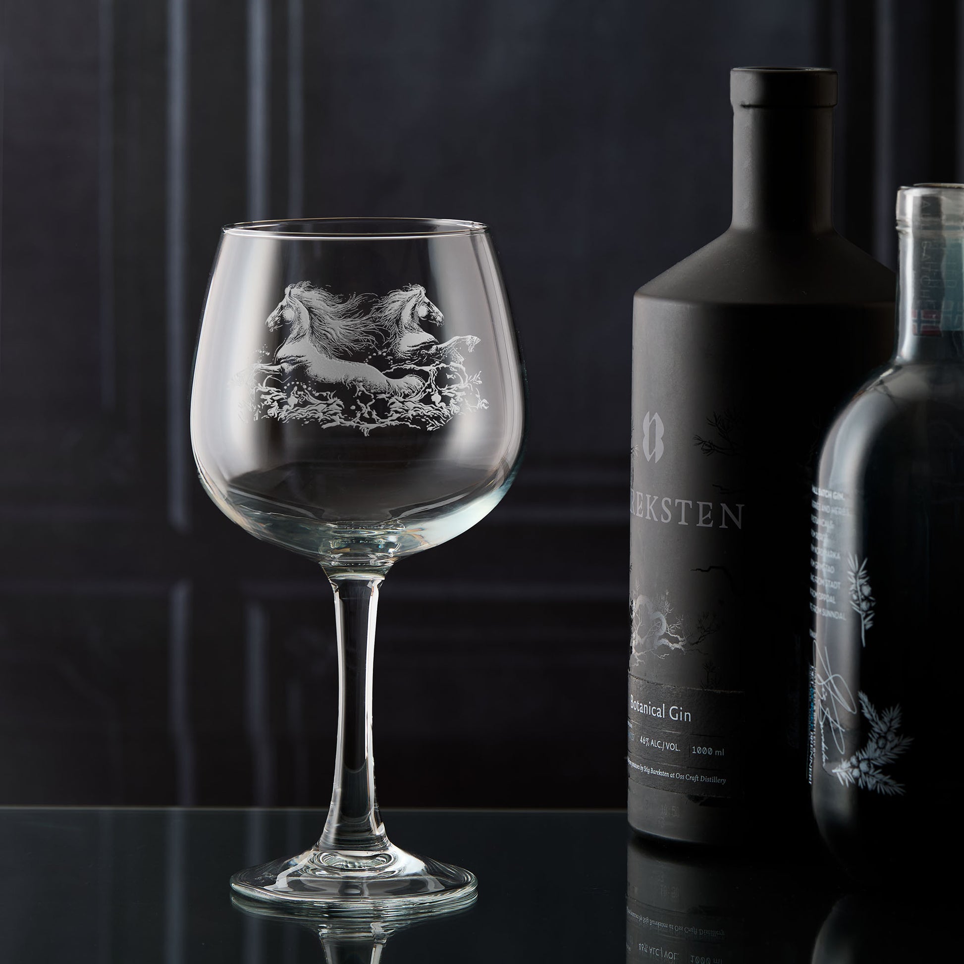 Gin glass engraved with two horses galloping through the water