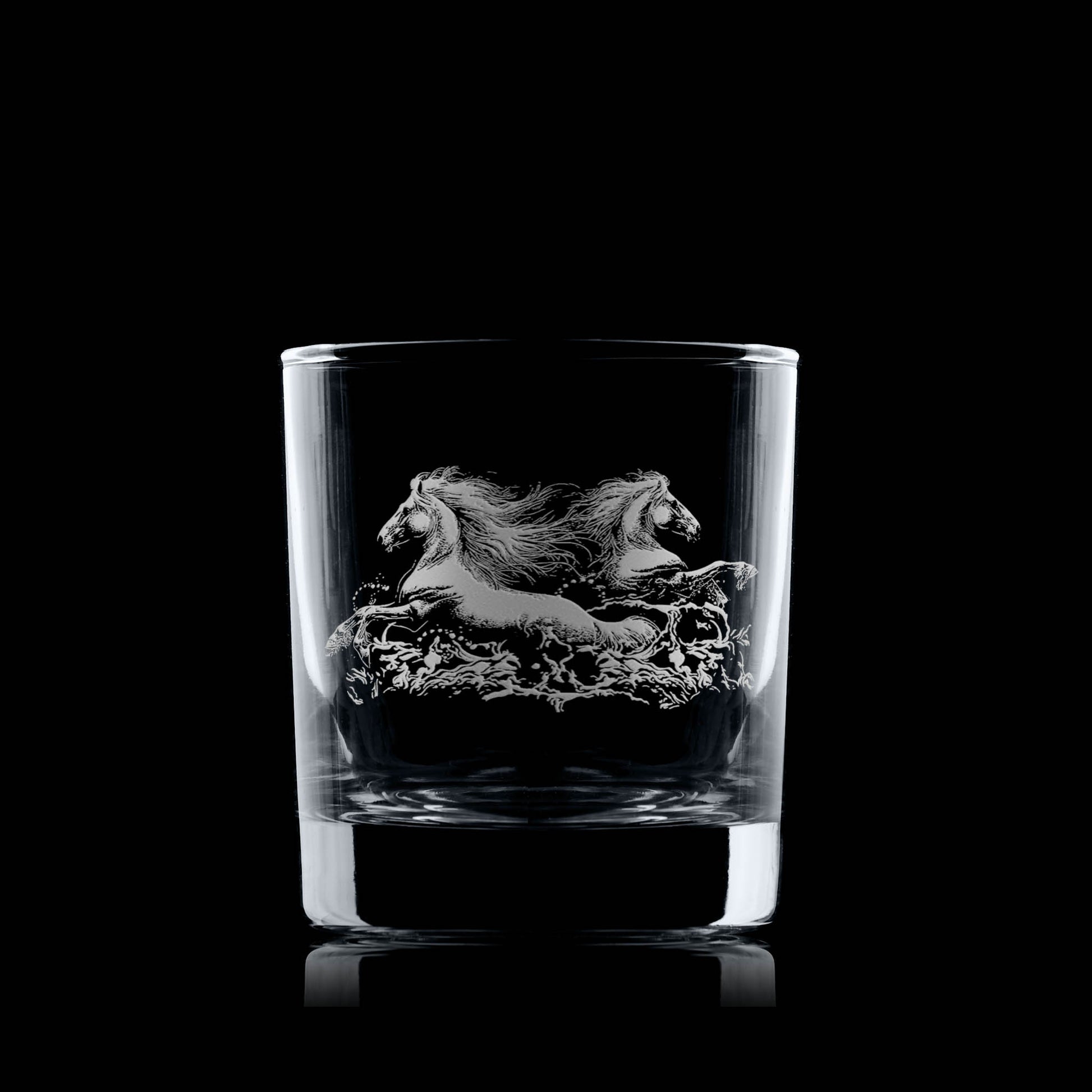 Two engraved kelpies rising from turbulent water on a whisky glass