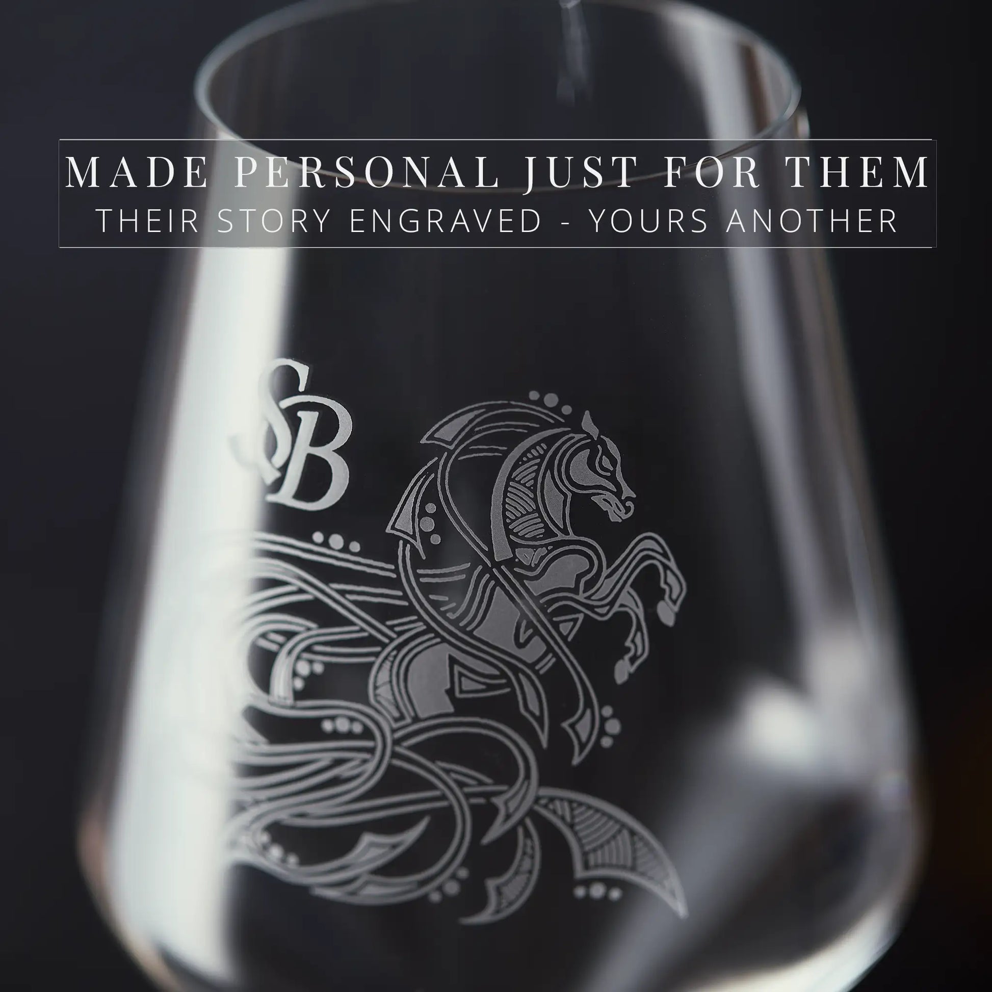 Close-up detail of engraved glassware with a horse design and text on a dark background
