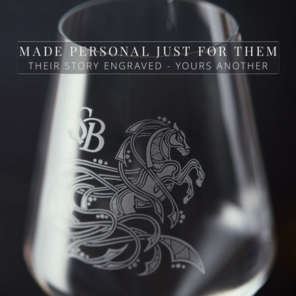 Close-up detail of engraved glassware with a horse design and text on a dark background
