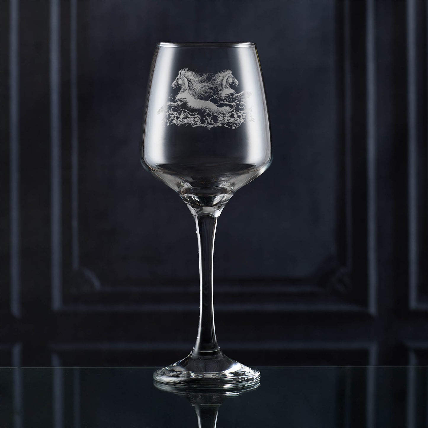 Wine glass with engraved horse design on a dark background