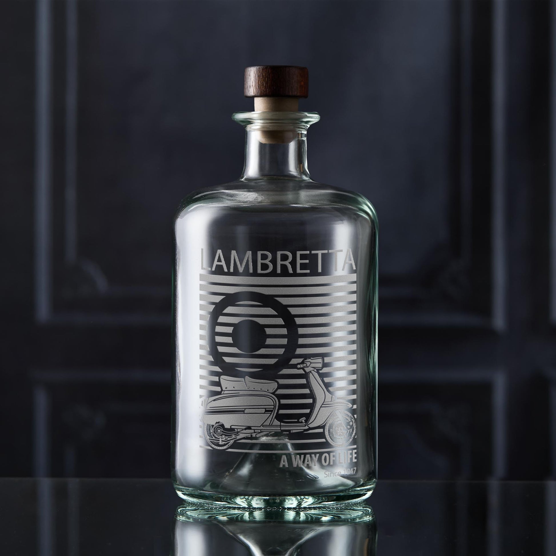 Clear glass apothecary bottle with a vinatge Lambretta scooter on a dark background