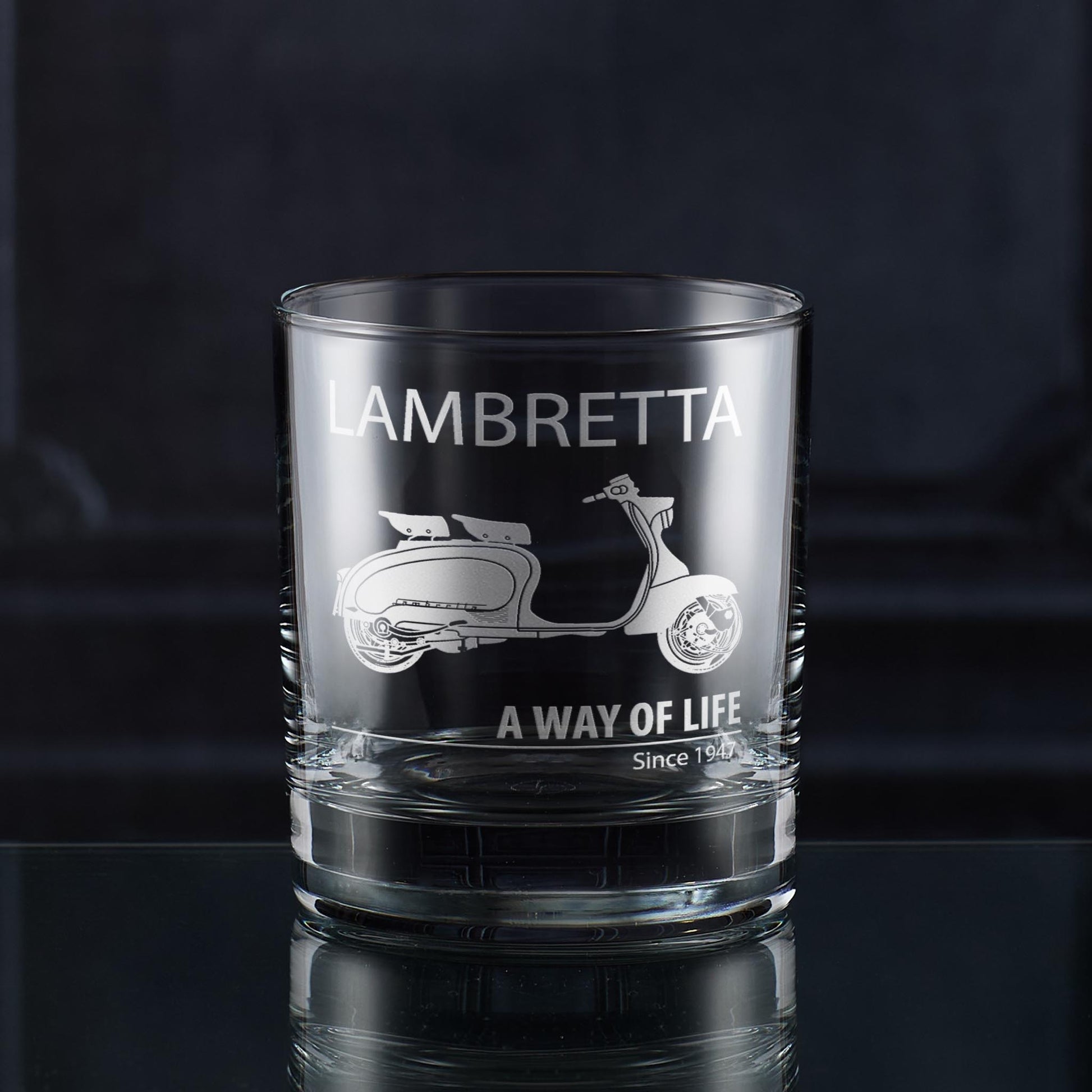 Glass tumbler with Lambretta scooter design and text on a dark background
