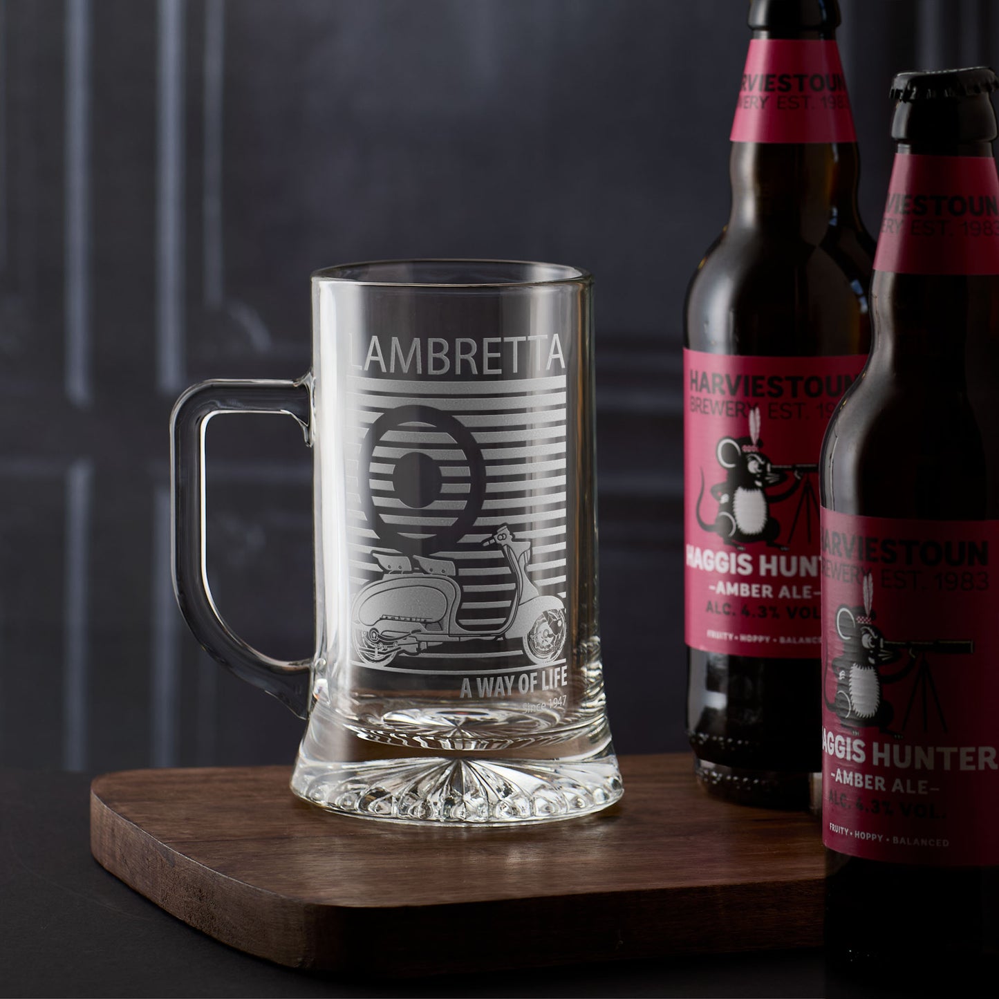 Lambretta tankard with engraved Li125 design on a wooden board with two bottles of beer in the background.