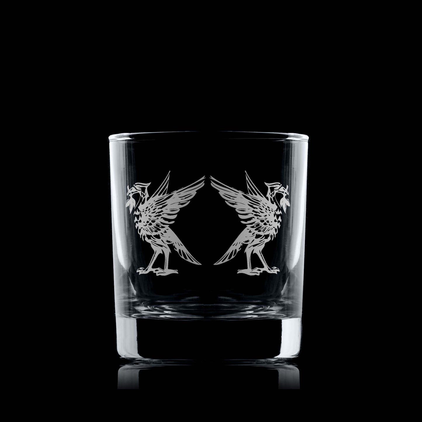 Whiskey tumbler with engraved Liverbird design on a black background
