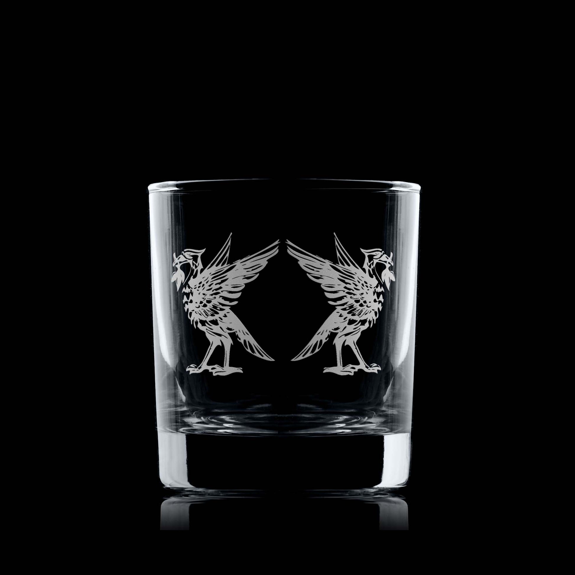 Whiskey tumbler with engraved Liverbird design on a black background