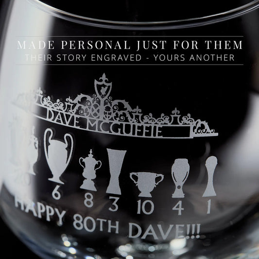 Engraved gin glass featuring the Shankly Gates in line-art style with football trophy silhouettes and personalised text, shown on a black background.