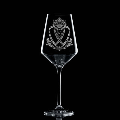 Atelier Edition wine glass engraved with a crowned Luckenbooth, thistles, and stag motif, shown on black background to highlight engraving detail