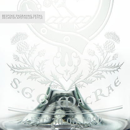 Close-up detail of a glass decanter with intricate engravings and personalised text on a white background