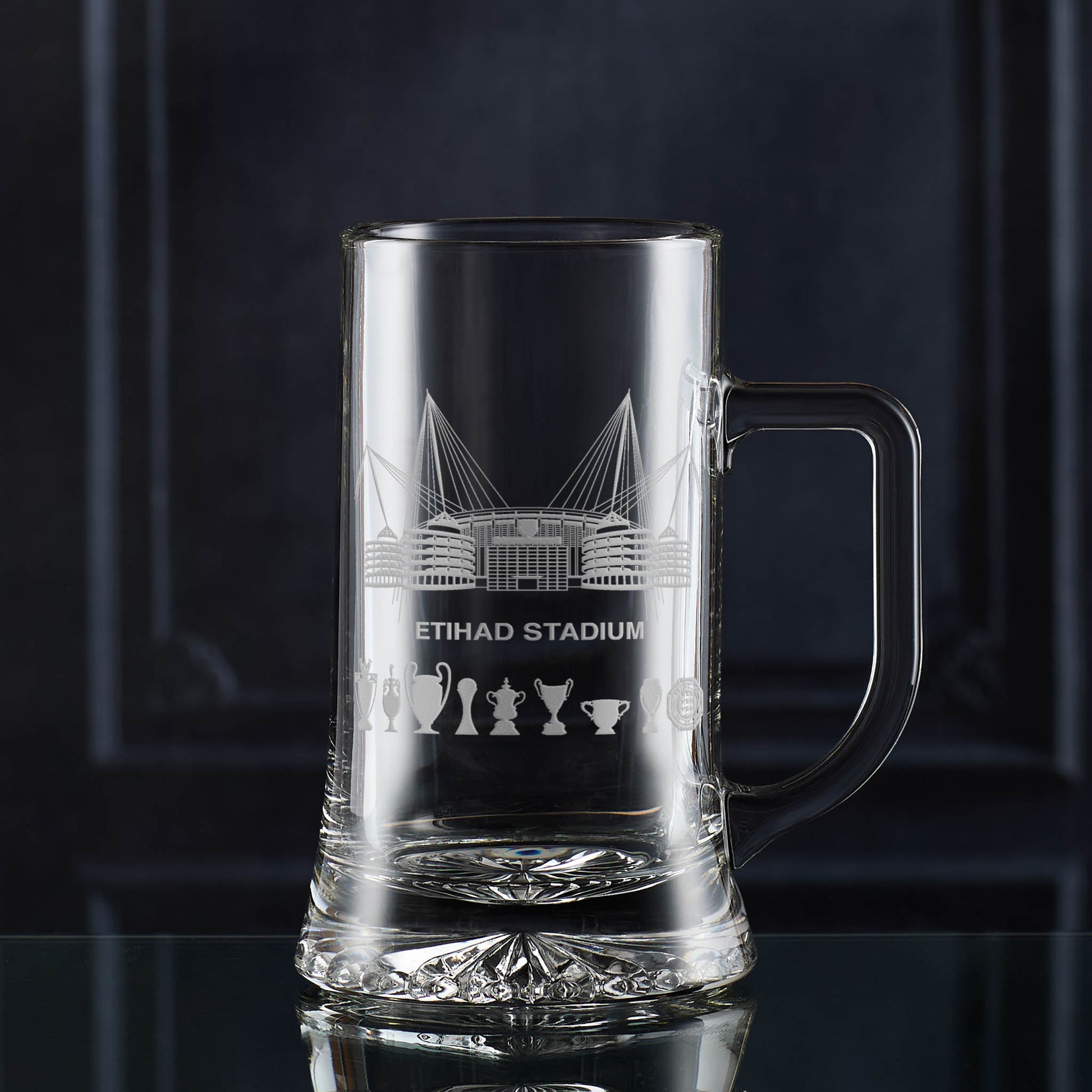 Engraved glass tankard featuring Etihad Stadium line art and trophy silhouettes, shown on a dark background.