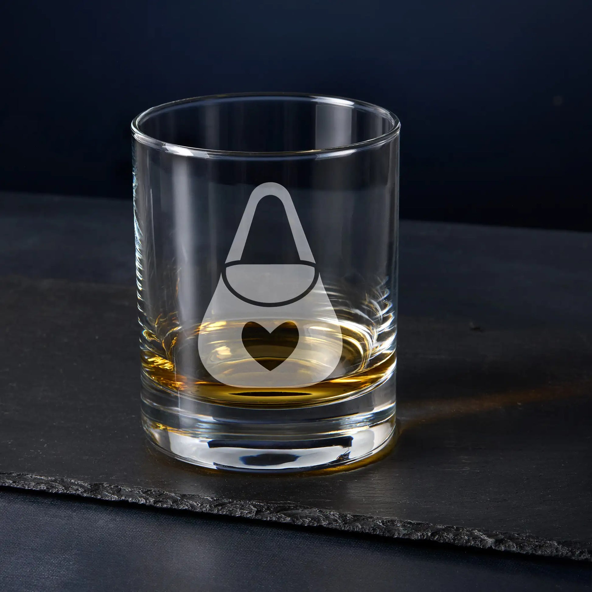 Masonic Almoner whisky glass engraved with collar jewel, photographed on black background