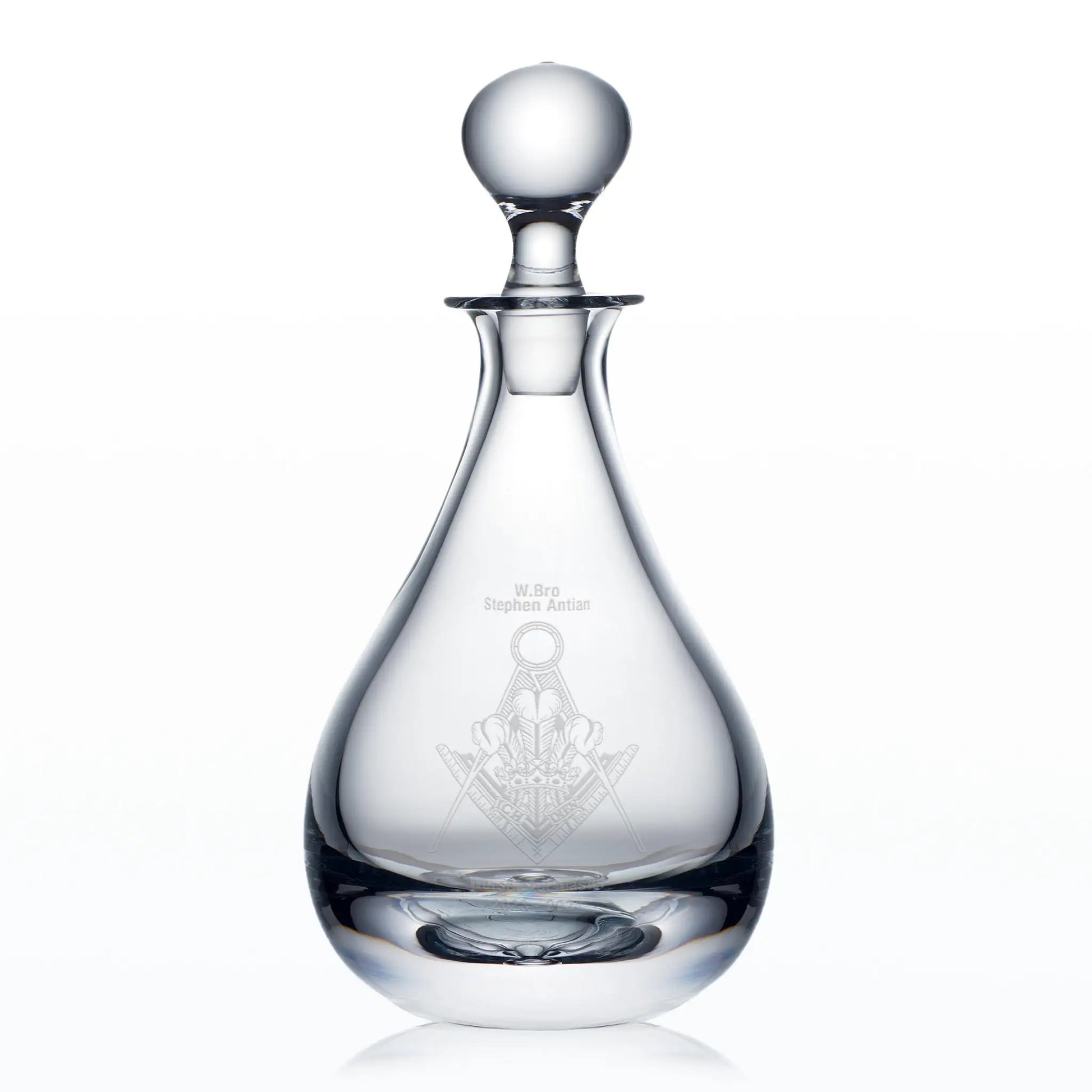 Clear glass decanter engraved Masonic lodge badge and spherical stopper on a white background