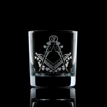 Engraved Irish Masonic whiskey glass with Square & Compass, shamrocks, and harp on black background