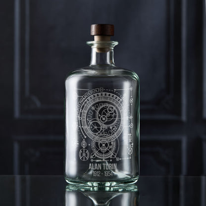 Clear glass decanter bottle with engraved maths design and wooden stopper on a dark background