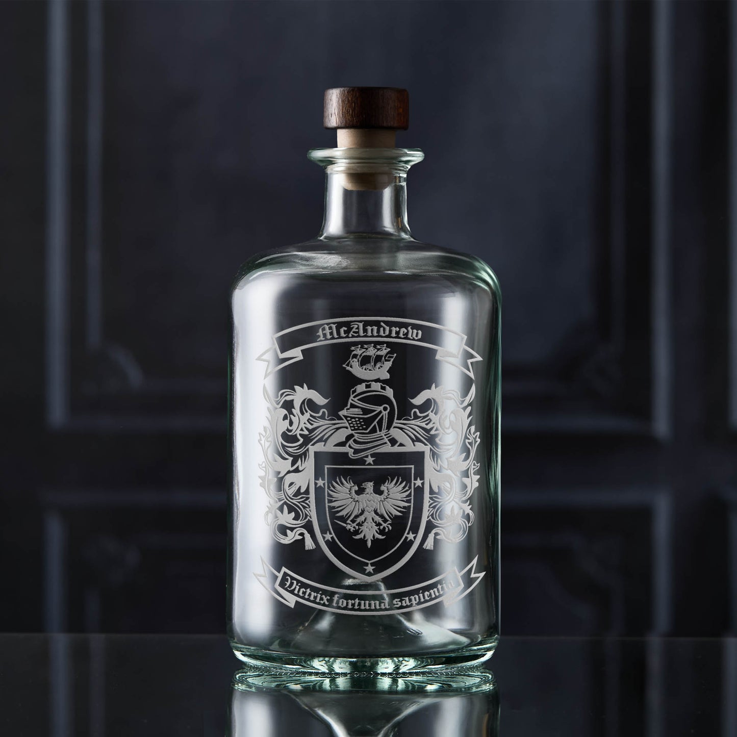 Hand-engraved family crest on apothecary-style glass decanter — McAndrew coat of arms, satin sandblasted finish.