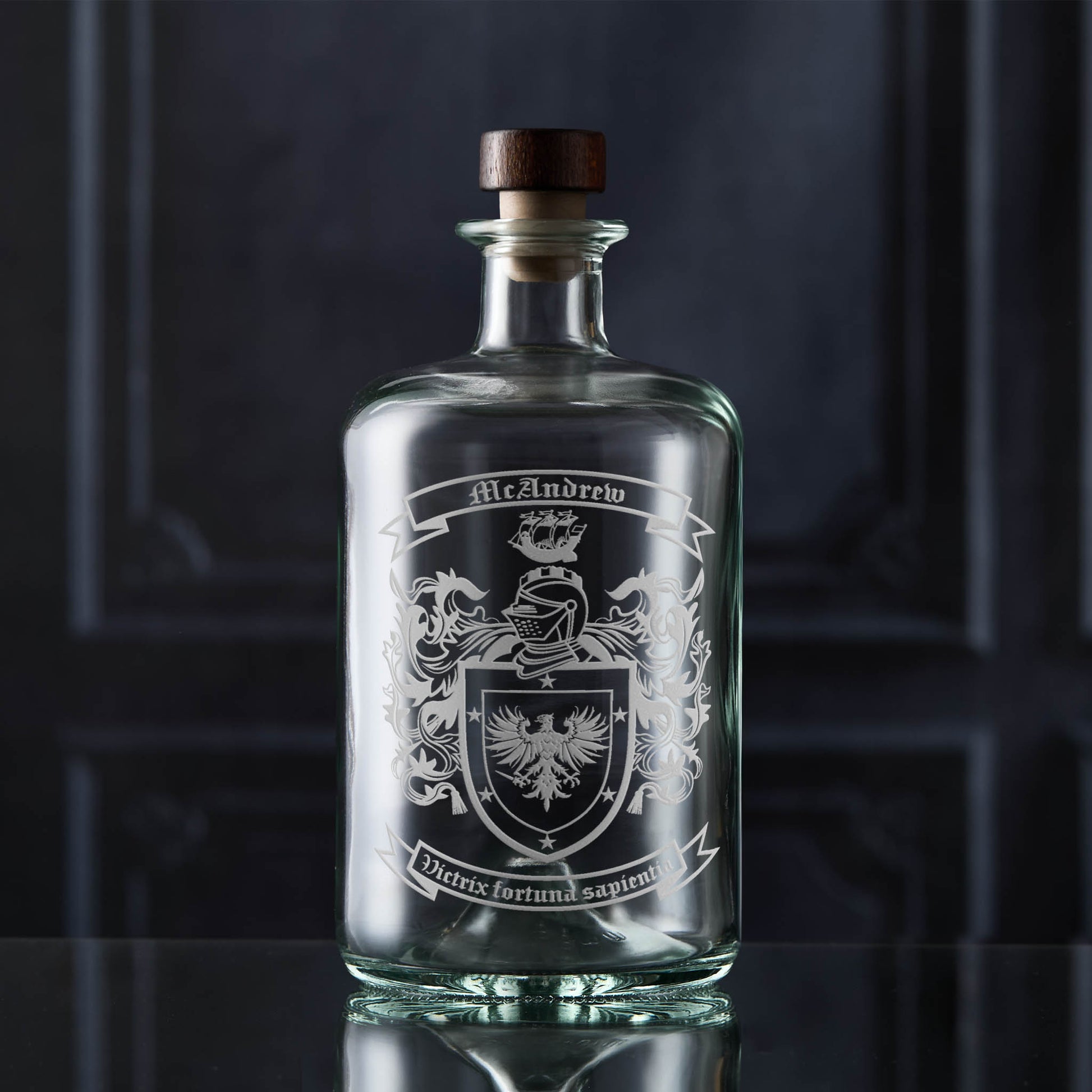 Hand-engraved family crest on apothecary-style glass decanter — McAndrew coat of arms, satin sandblasted finish.