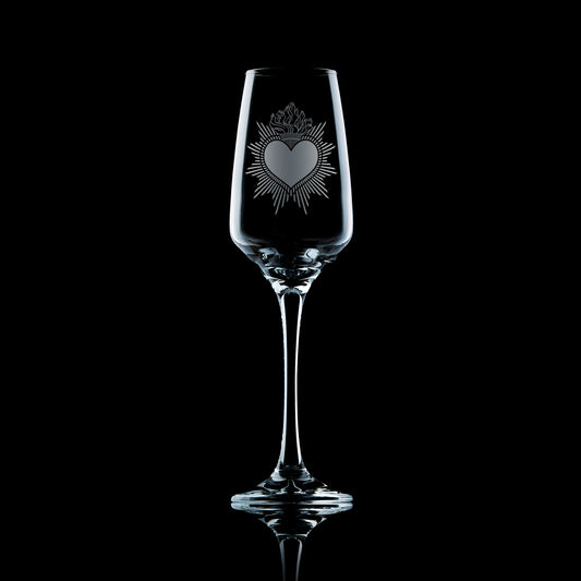 engraved milagro sacred heart prosecco glass or champagne flute on a black background