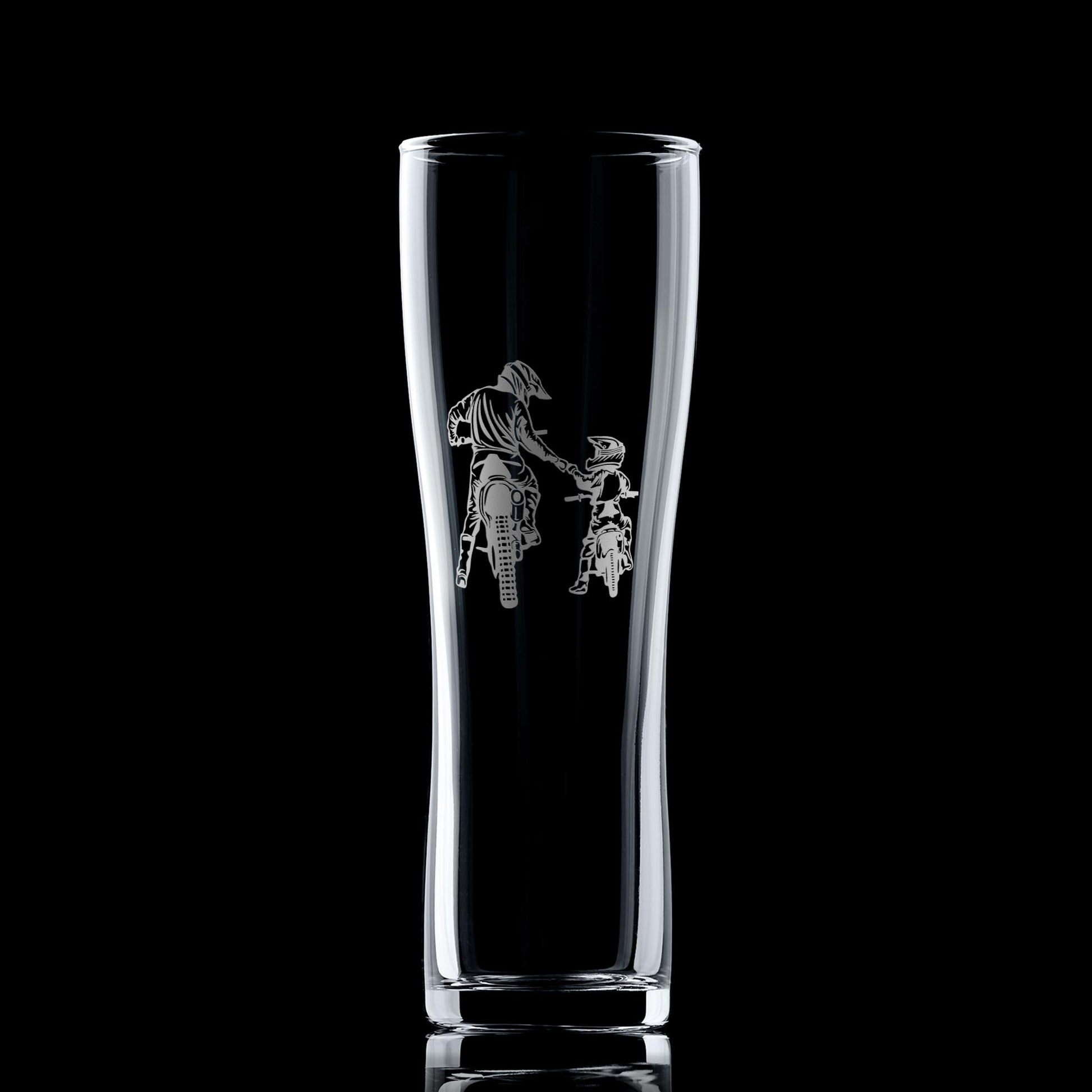 Clear glass tumbler with engraved design of a person on a motorcycle a black background