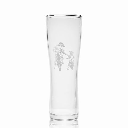 Pint glass with engraved motobike design on a white background