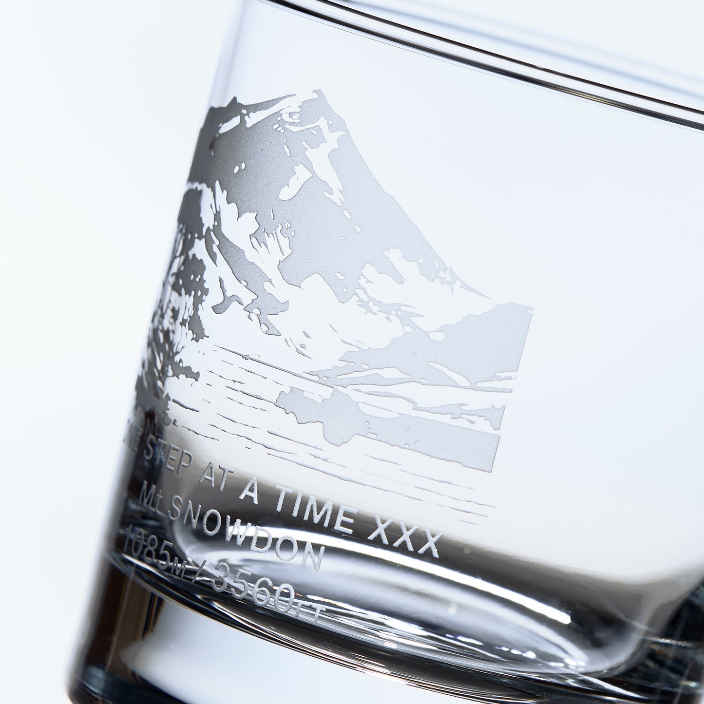 close up details  of a whisky glass sanblast engraved with Mt Snowdon in Wales