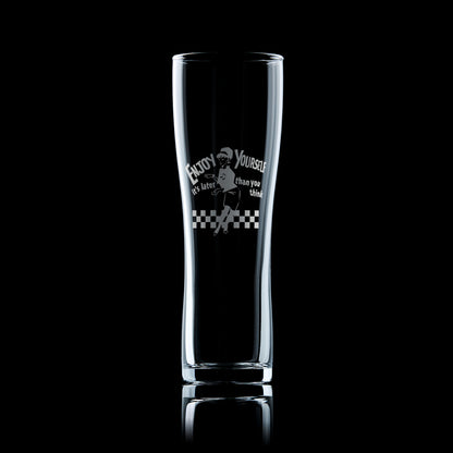 Engraved pint glass with the Original Beat Girl dancing on a checkerboard floor and the words “Enjoy Yourself,"