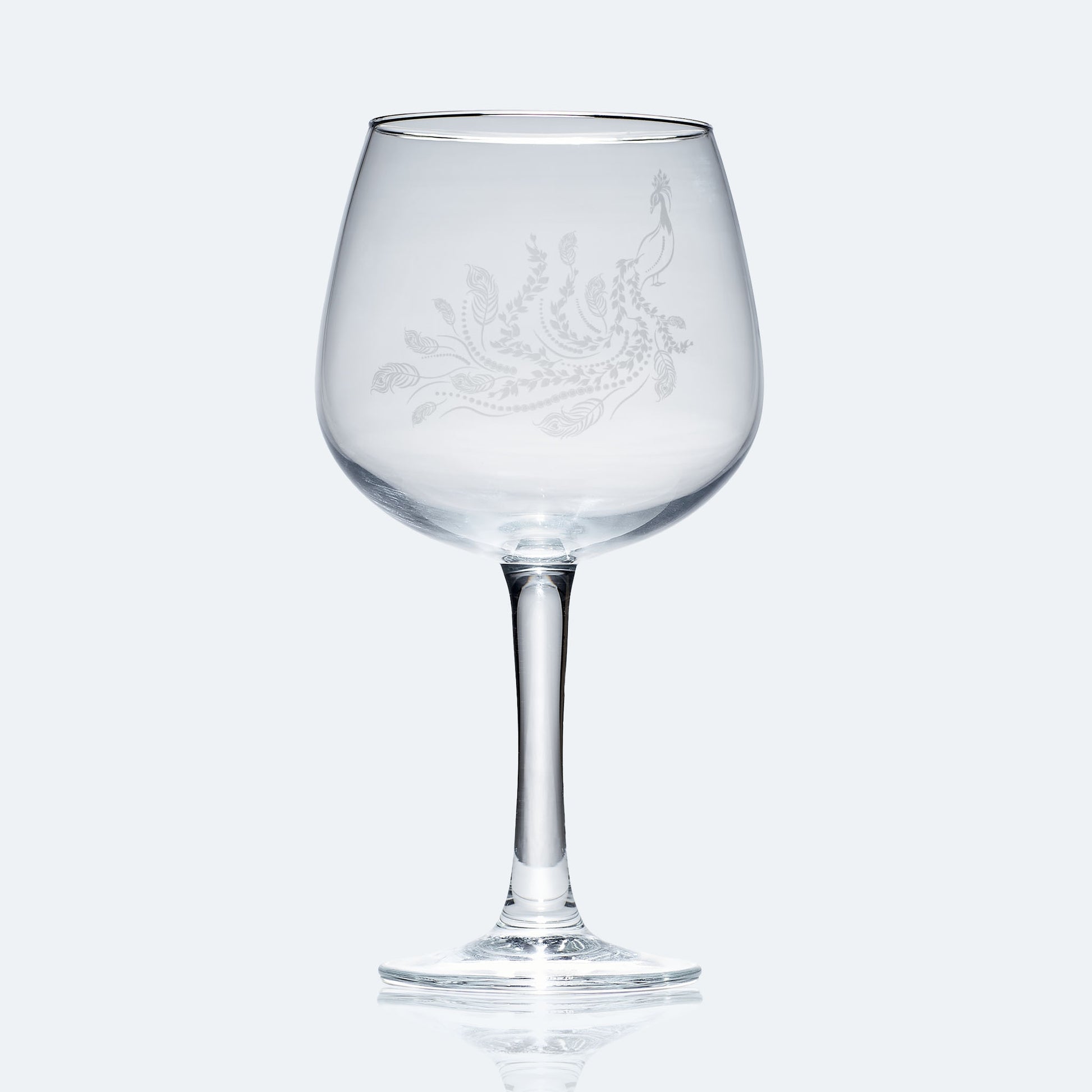 engraved balloon gin glass etched with a peacock 