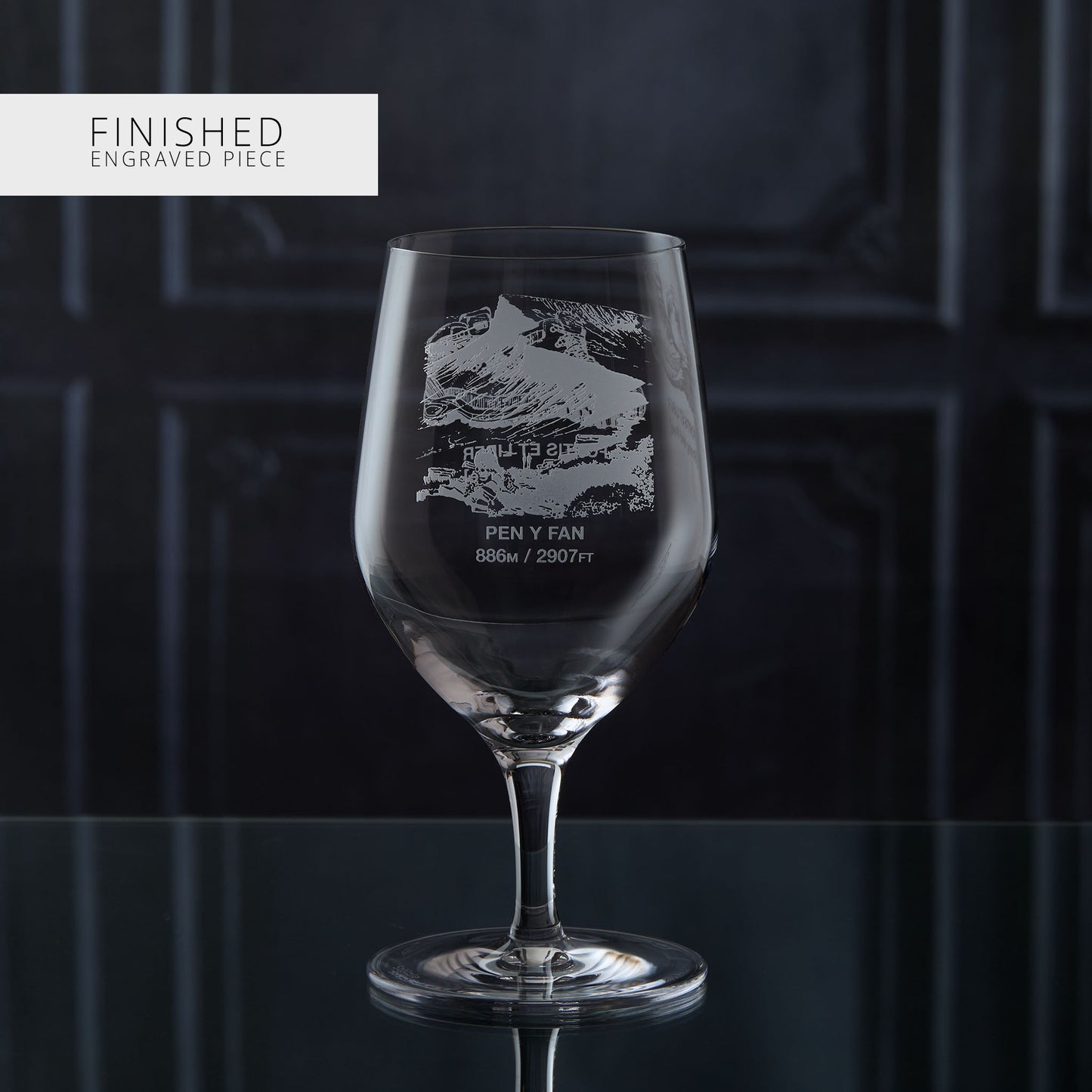 Stemmed water glass with engraved welsh mountain design on a dark background