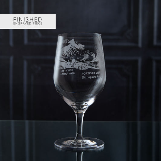 Engraved glass with text walking boots and a mountain design on a dark background