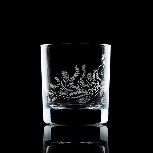 whisky glass engraved with a peacock and its feathers