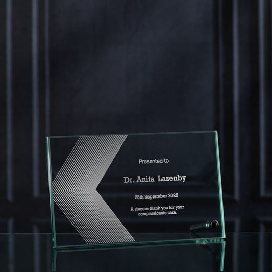 Glass award with engraved logo and text on a dark background