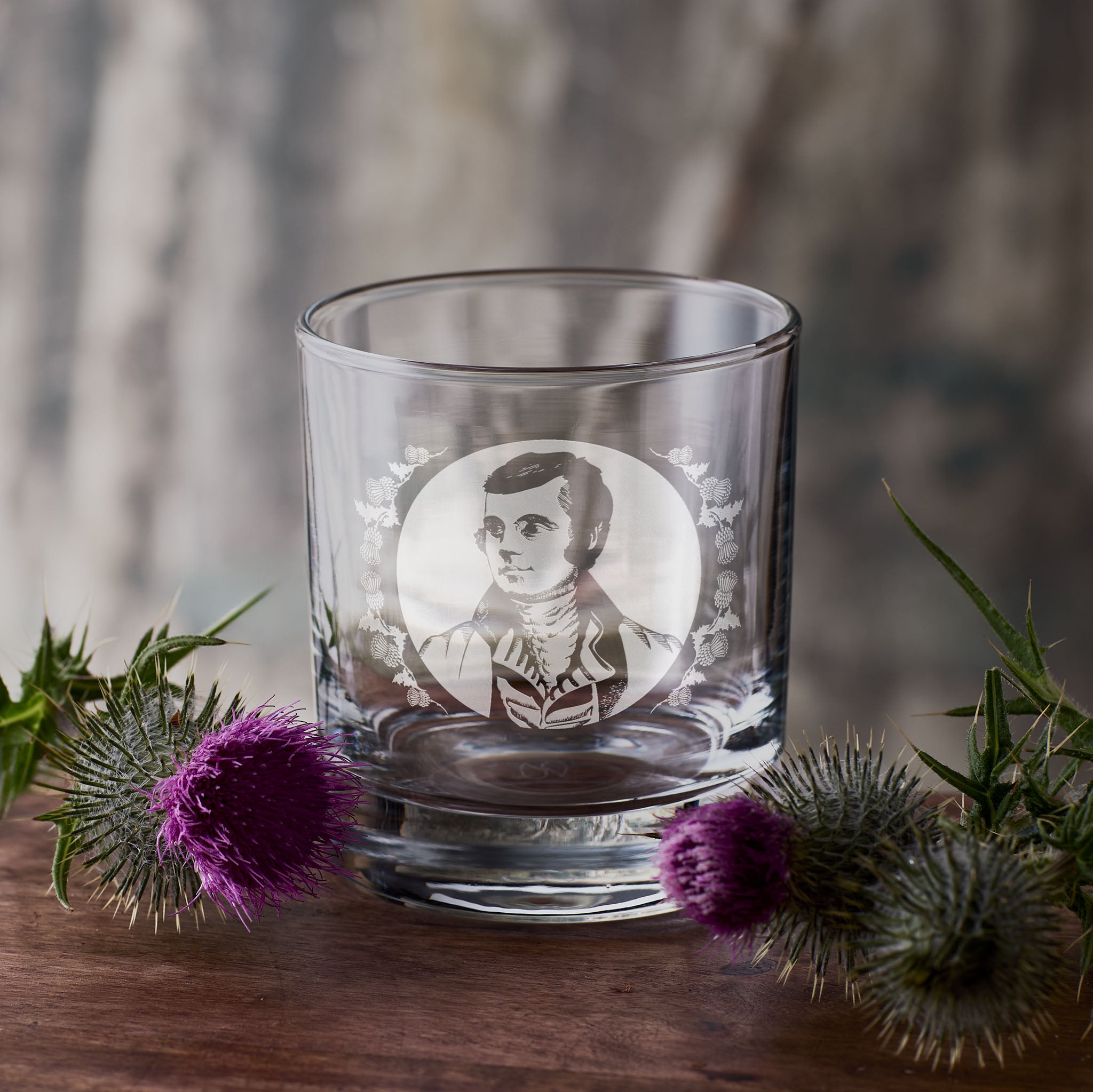 portrait of the Scottish poet Robert Burns engraved into a whisky glass with thistle design