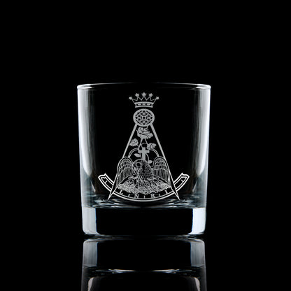 Engraved Rose Croix whisky glass with Latin cross and rose emblem, photographed on a black background