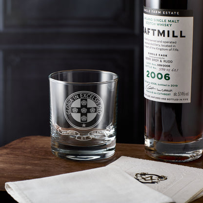 Bottle of Daftmill whisky and a whisky glass on a wooden surface with a dark background