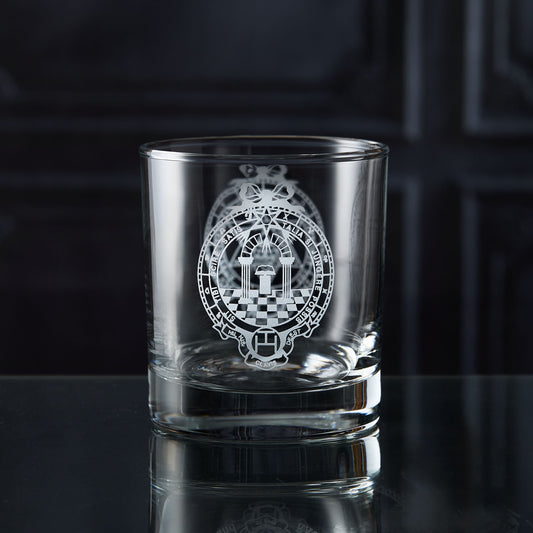 Clear glass whisky tumbler with engraved masonic royal arch design on a dark surface