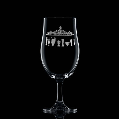Front-facing 620ml engraved stemmed beer glass with Shankly Gates and LFC trophy silhouettes, shown on a black background to highlight engraving detail