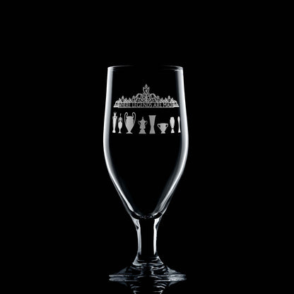 Front-facing engraved 380ml stemmed beer glass with Shankly Gates and trophy silhouettes, shown on a black background to highlight engraving detail