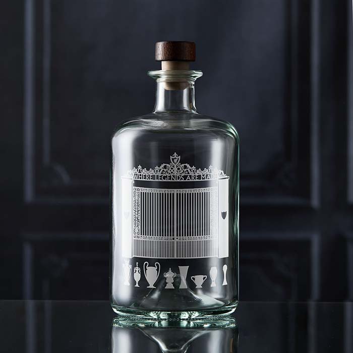 Clear glass bottle with engraved liverpool football design on a dark background