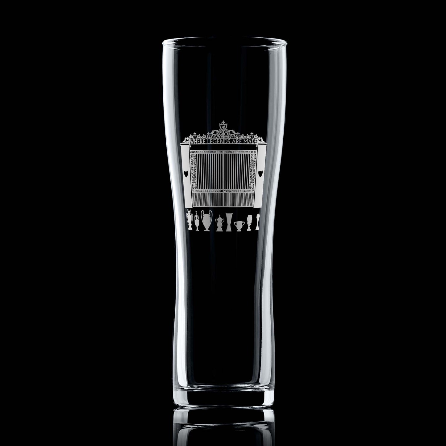 Engraved pint glass with Shankly Gates entrance to a Livepool football stadium and trophy silhouettes, shown front-facing on a black background.
