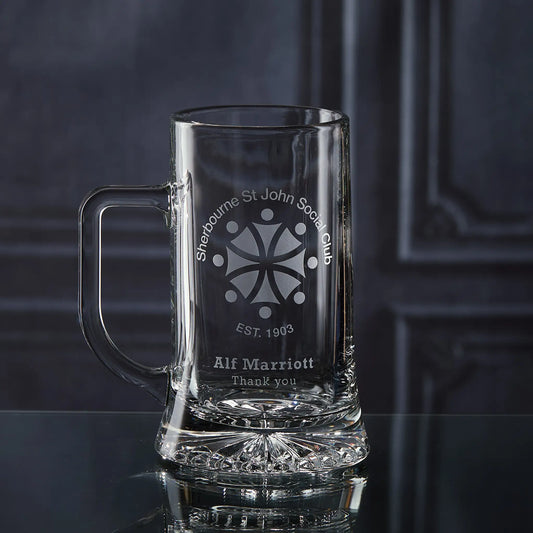 Clear glass mug with engraved corporate logo and personalised text on a dark background