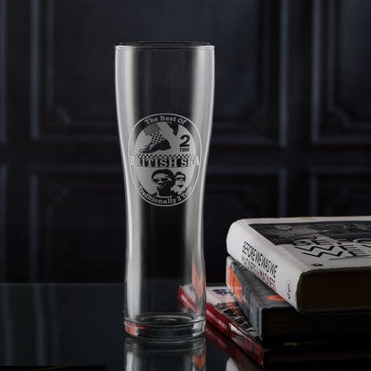 Pint glass engraved with a british ska and two tone design on a dark surface with books