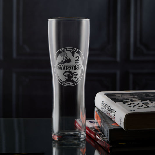Pint glass engraved with a british ska and two tone design on a dark surface with books