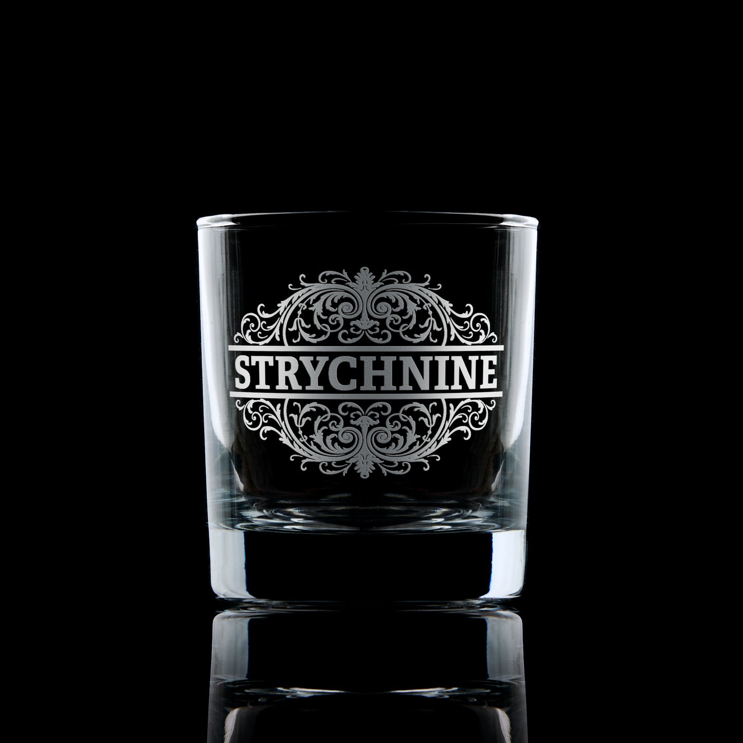 Strychnine engraved whisky glass photographed on a dark background