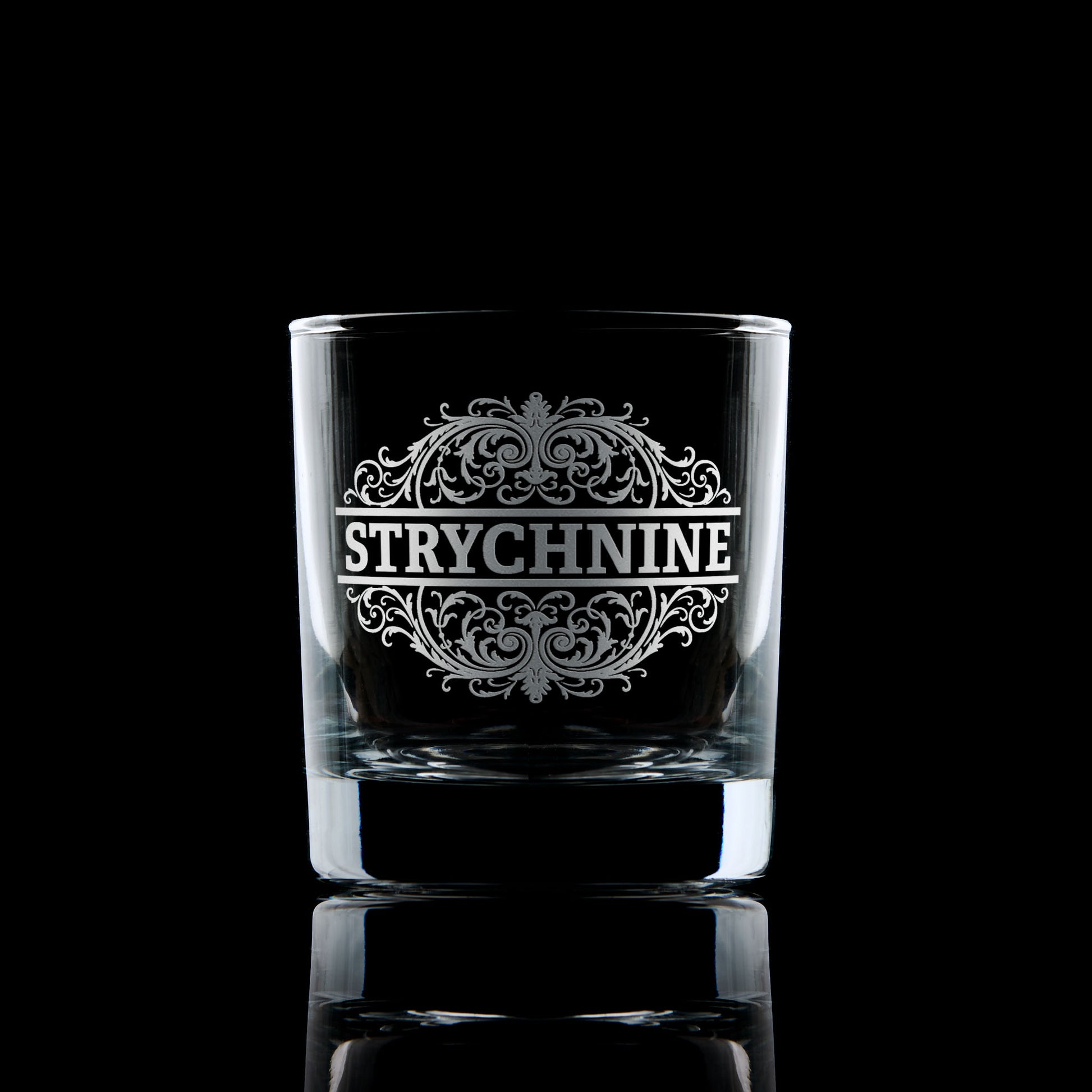 Strychnine engraved whisky glass photographed on a dark background
