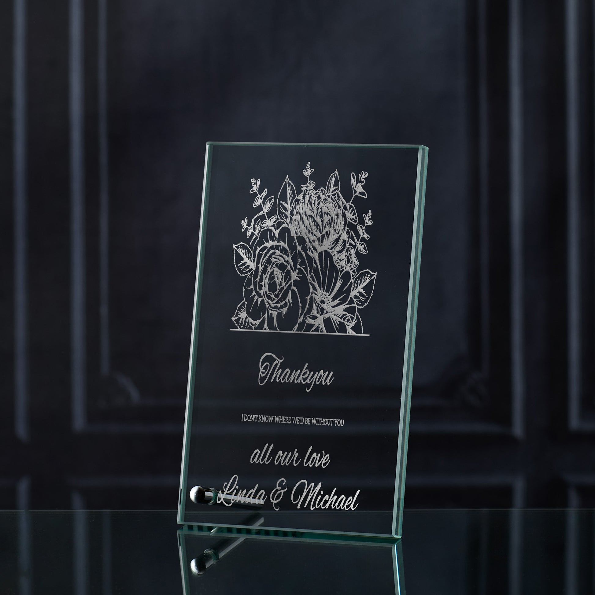 Glass plaque with floral design and engraved thankyou text on a dark background