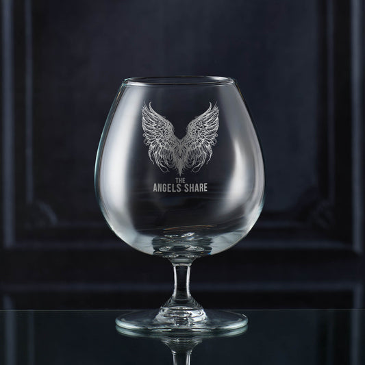 Brandy glass with 'The Angels Share' etching on a dark background
