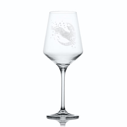 Wine glass with intricate hare, moon and stars design on a white background