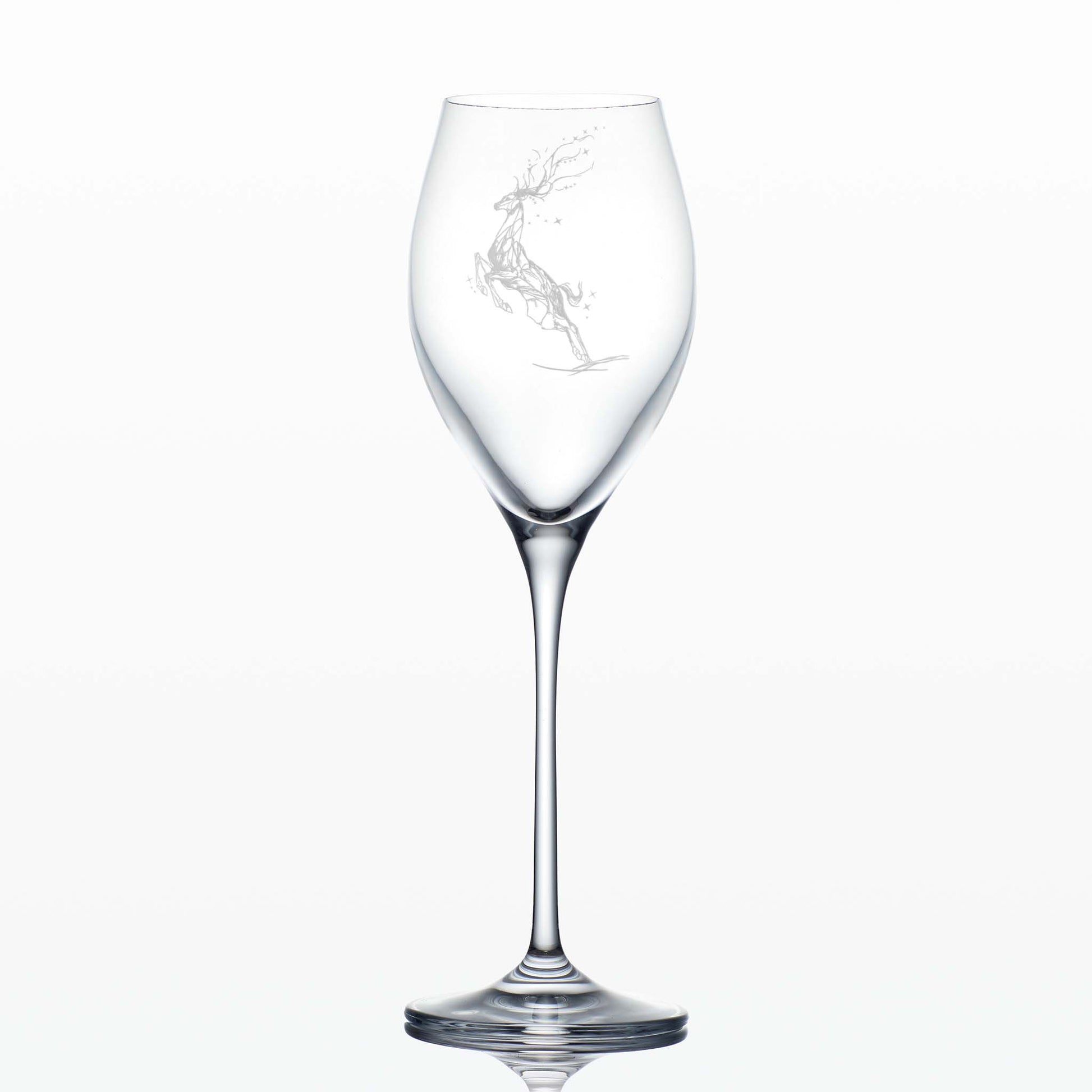 Tall engraved prosecco glass featuring a Winter Stag leaping ithrough stars on a white background