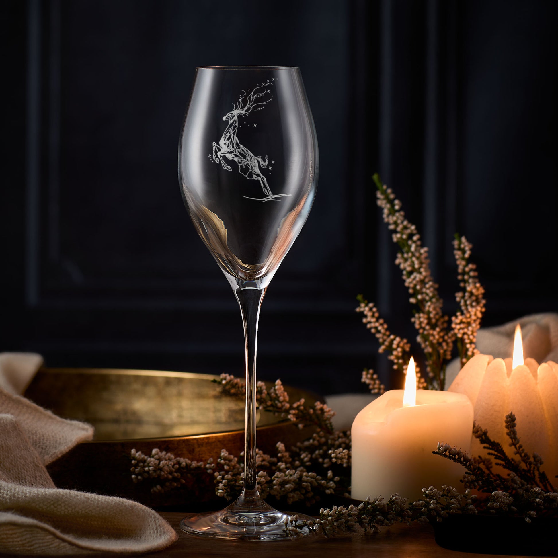 Leaping stag prosecco glass with deer engraving on a table with candles and flowers